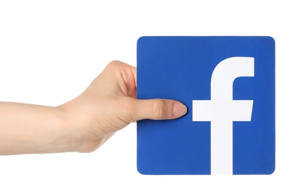 Рука тримає facebook логотип, надрукований на папері на білому тлі — стокове фото