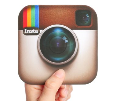 Hand holds Instagram logotype printed on paper