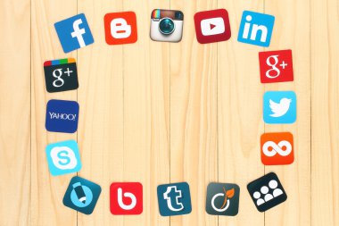 Famous social media icons placed around on wooden background