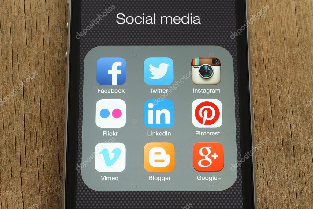 KIEV, UKRAINE - JUNE 23, 2015: iPhone with popular social media icons on its screen on wooden background