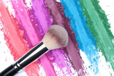 Kırık ve ezilmiş göz makyajı paleti, fırçayla fırça darbeleri, şeffaf bir arkaplan, üst görünüm. Örnek kozmetik konsepti