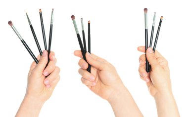 Şeffaf arka planda izole edilmiş kozmetik fırçaları tutan bir çift el. Makyaj, kişisel bakım ve yaratıcı projeler için güzellik kolajı