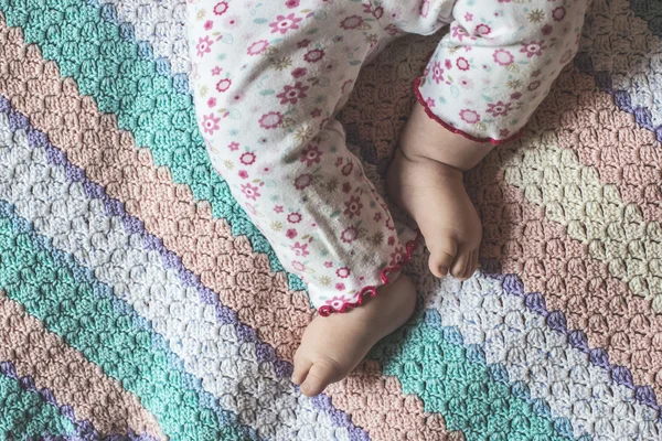 Piedi del bambino sul letto — Foto Stock