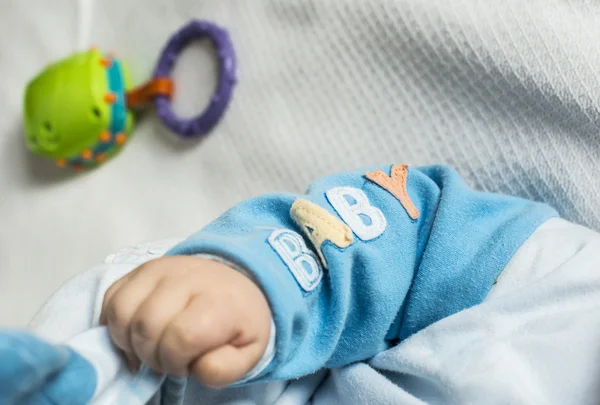 Mano de bebé y texto bebé en la ropa —  Fotos de Stock