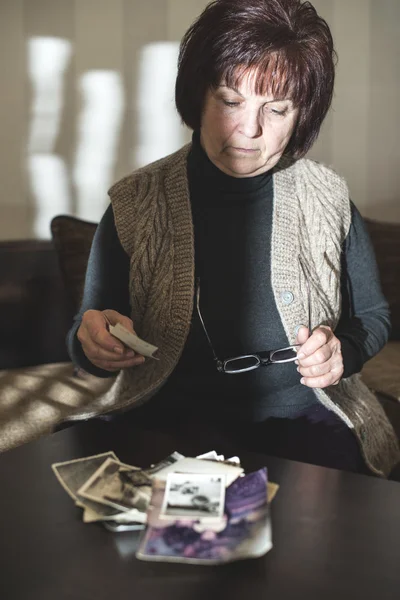 Senior kobieta oglądając stare zdjęcia — Zdjęcie stockowe