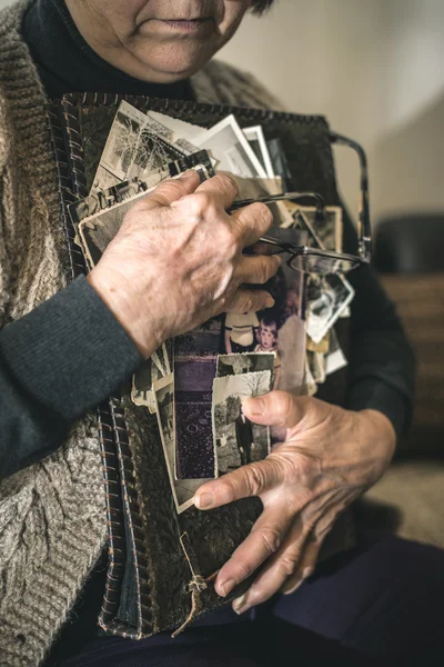 Senior vrouw kijken naar oude foto 's — Stockfoto