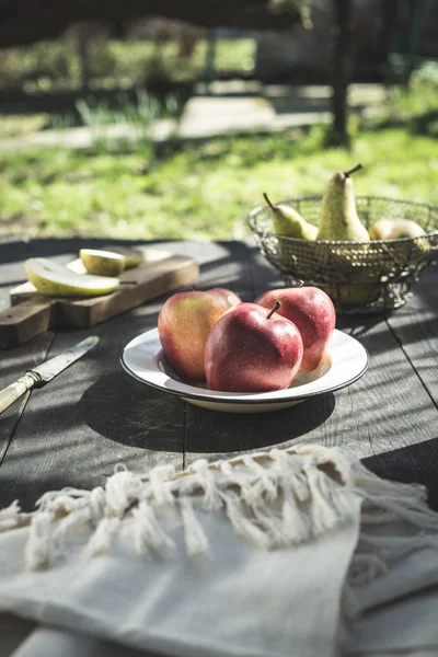Нарезанные яблоки на деревянной доске и тарелке — стоковое фото