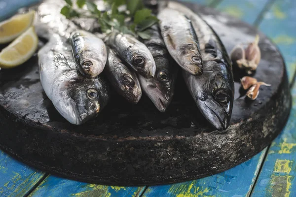 Raw fish on wooden board — Stock Photo, Image