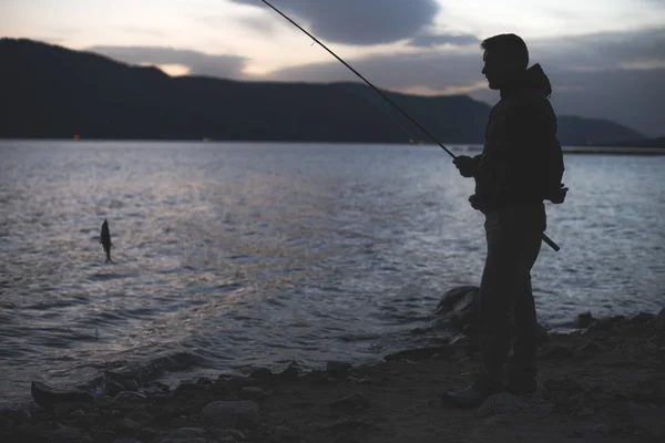 Homem Pescando Lago Montanha Nascer Sol Pouca Luz Roupas Casuais — Fotografia de Stock