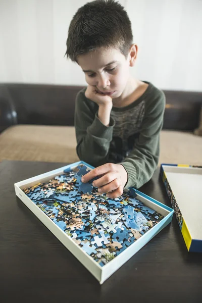 Enfant avec pile de puzzles — Photo