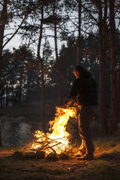 Člověk zapálí oheň v krbu v přírodě — Stock fotografie