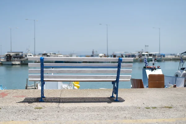 Bench on the beach and boats — Stock Photo, Image