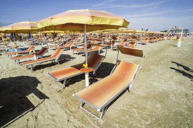 kumsalda güneşlik ve şemsiyeler.