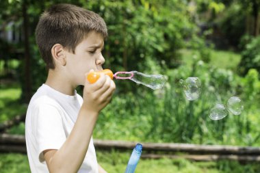 Çocuk baloncuklar yapar