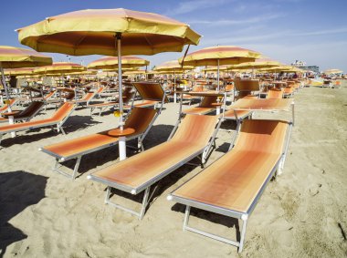 Turuncu şezlong ve şemsiyeler