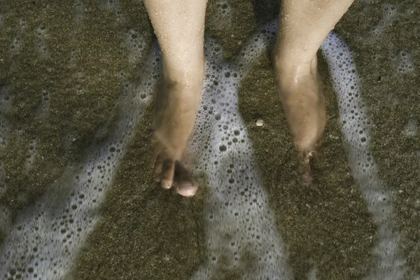 Duas pernas nas ondas do mar — Fotografia de Stock