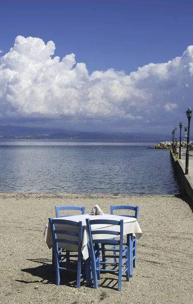 Tavolo in taverna greca sulla spiaggia — Foto Stock