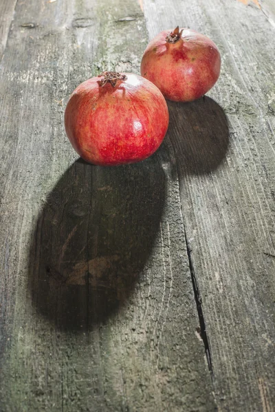 Pomegranates on wooden table — Stock Photo, Image