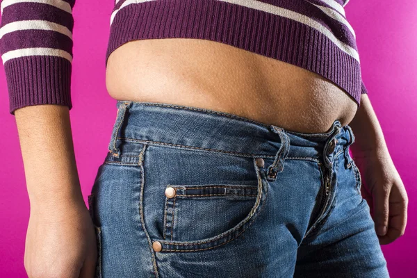 Woman in jeans shows overweight — Stock Photo, Image