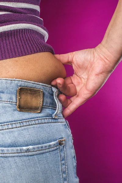 Žena s džíny ukazuje břicho — Stock fotografie