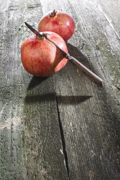 Pomegranates with knife on table — Stock Photo, Image