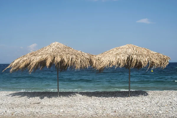 Straw umbrellas on the beach — Stock Photo, Image