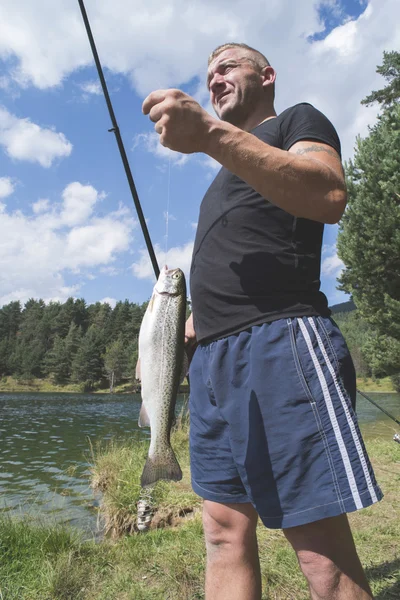 Мужчина рыбачит в озере — стоковое фото
