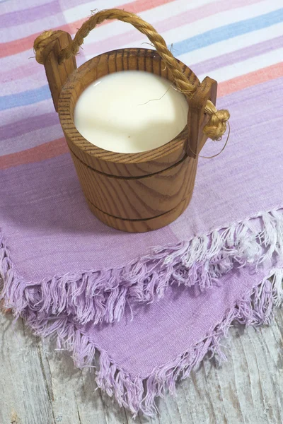 Vintage small wooden mug of milk