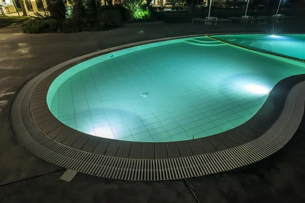 Pool, Liegestühle und Sonnenschirme in der Nacht — Stockfoto