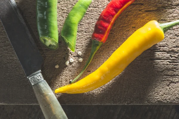 Pimentos quentes na placa de corte de madeira — Fotografia de Stock