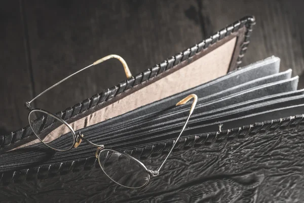 Old round glasses and photo album — Stock Photo, Image