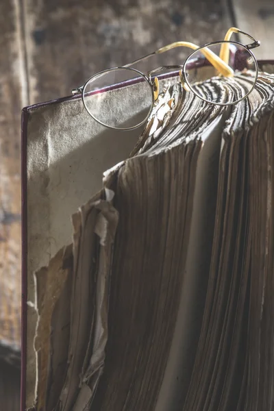 Старые круглые очки и книга — стоковое фото