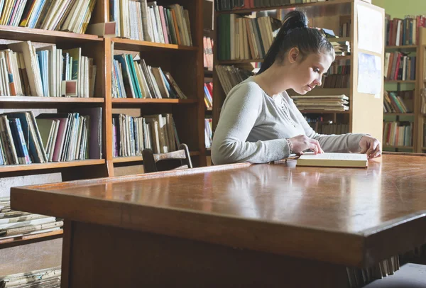 Vrouwelijke student meisje in bibliotheek — Stockfoto