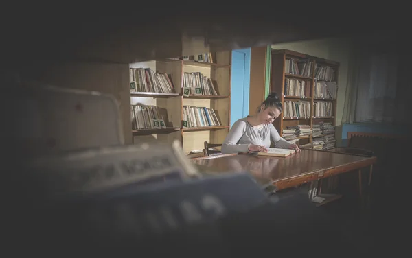 Девушка-студентка в библиотеке — стоковое фото