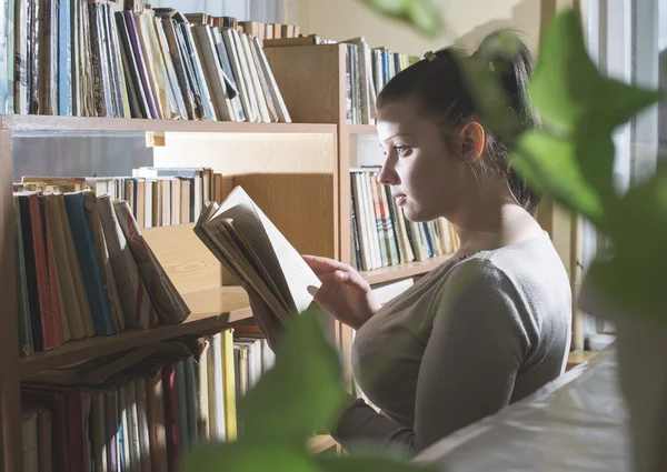 Vrouwelijke student meisje in bibliotheek — Stockfoto