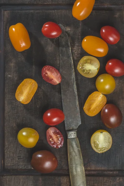 Tomatoes on wooden board and knife — Stock Photo, Image