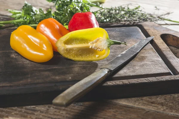 Peperoni su tavola di legno e coltello — Foto Stock