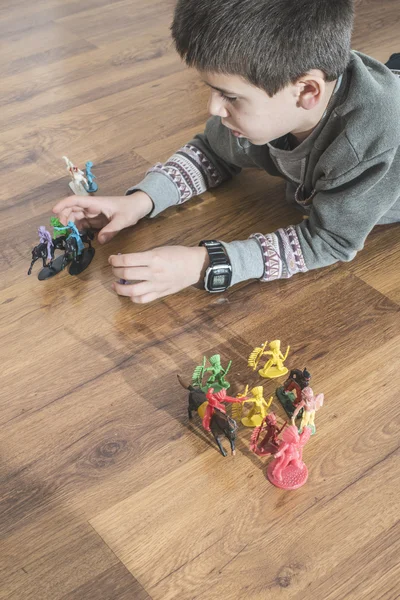 Niño jugando con juguetes pequeños — Foto de Stock