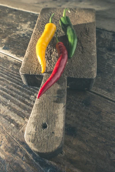 Pimentos quentes na placa de corte de madeira — Fotografia de Stock