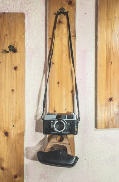 Vintage photo camera hooked on wall — Stock Photo, Image