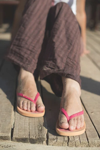 Voeten in slipper op strand — Stockfoto