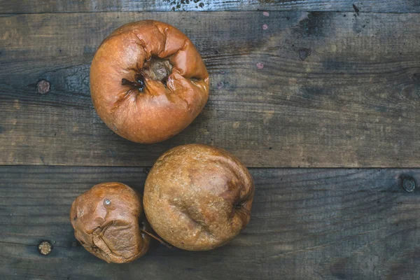 Faule Äpfel auf Holz — Stockfoto