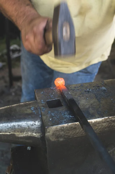 Blacksmith forges iron on anvil — Stock Photo, Image