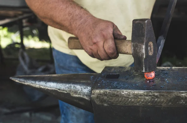 Blacksmith forges iron on anvil — Stock Photo, Image