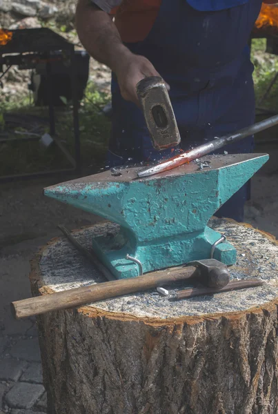 Blacksmith forges iron on anvil — Stock Photo, Image