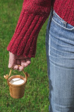 Kadın süt küçük ahşap kupa tutun