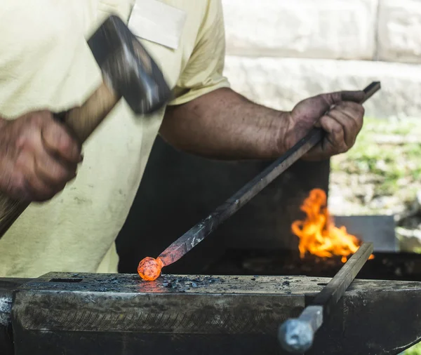 Kovář kují železo na kovadlinu — Stock fotografie