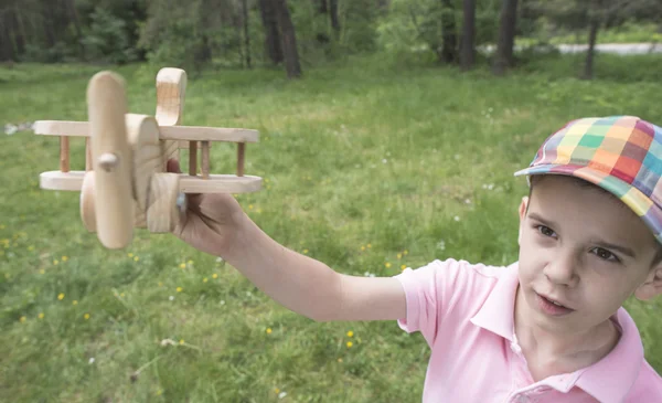 Child plaing with wooden plane — Stock Photo, Image