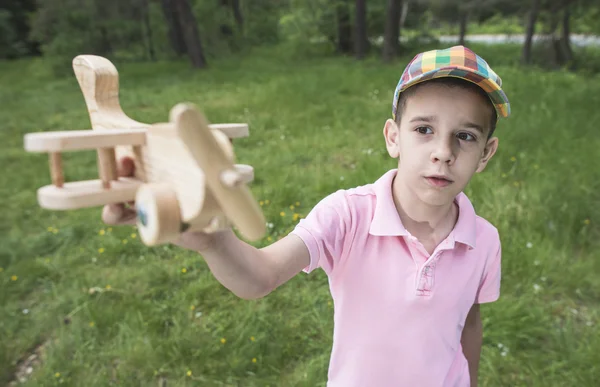 Child plaing with wooden plane — Stock Photo, Image