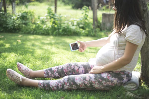 Zwangere vrouw met smartphone — Stockfoto